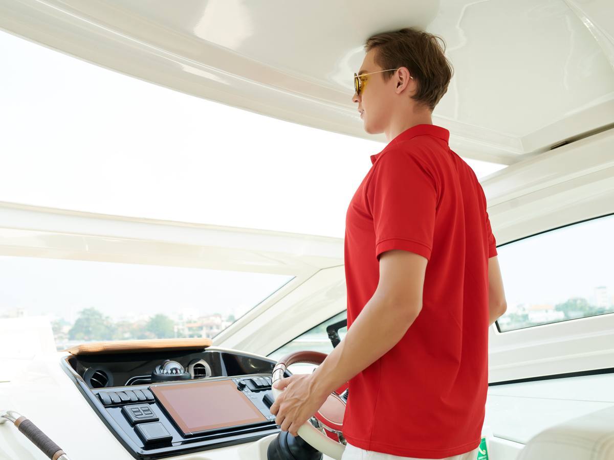 A skipper at the helm of a yacht