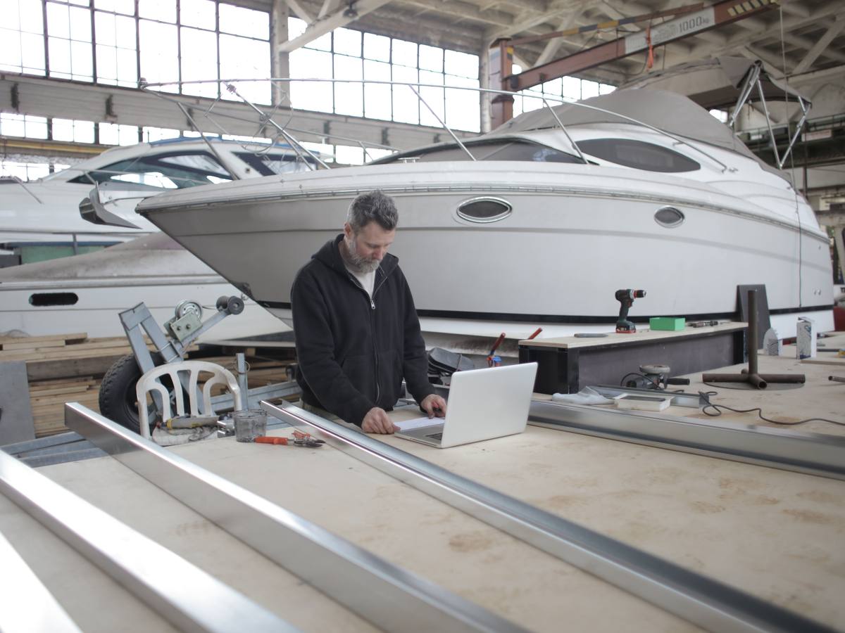 A technician managing yacht paperwork and coordination in the boatyard